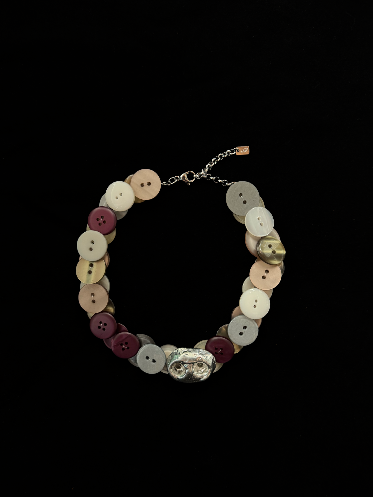 Handmade choker by weARCHIVE made from vintage buttons in soft tones, centered with a silver coffeebean charm. Upcycled, on trend, and one of a kind.