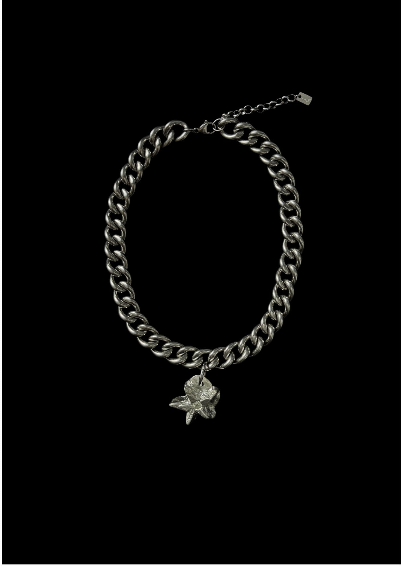 Silver chain bracelet with a flower charm on a black background