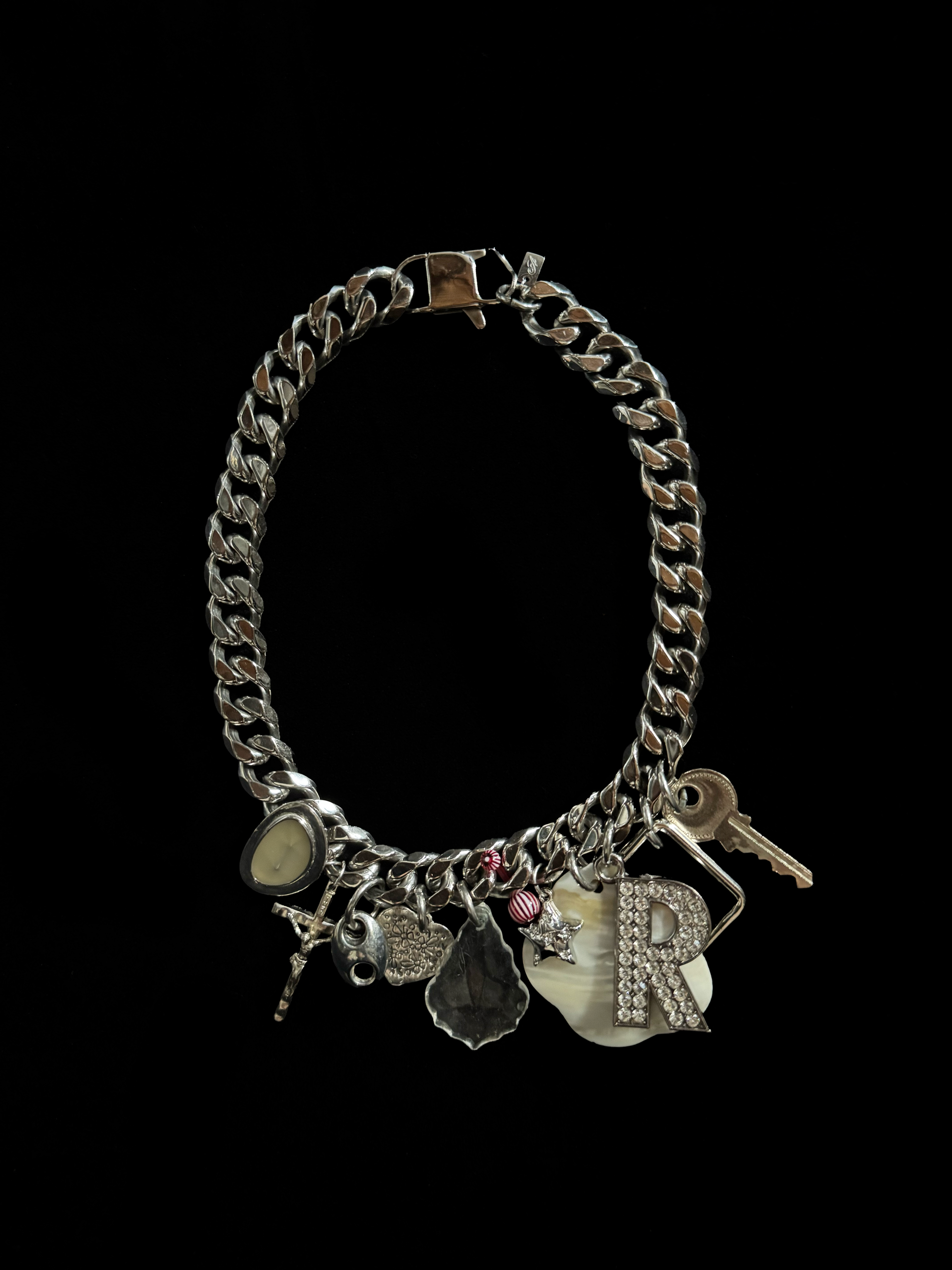 Upcycled charm necklace by weARCHIVE with thick stainless steel chain, featuring vintage charms: key, rhinestone R, cross, shell and more