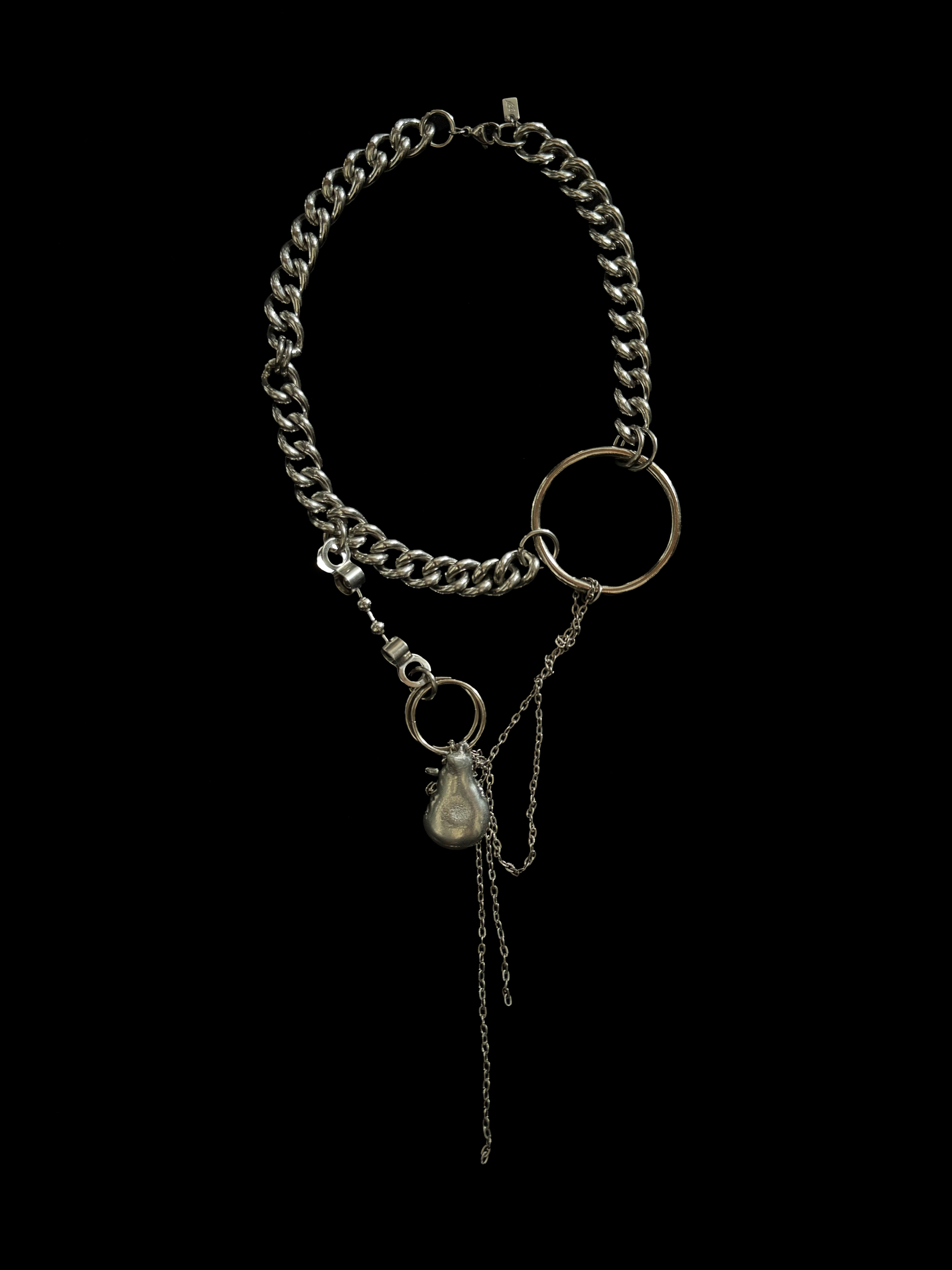 Chunky upcycled necklace by weARCHIVE with silver curb chain, oversized metal rings, and dangling melted drop-shaped charm. Edgy, bold, and handmade.