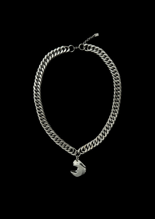 Silver chain bracelet with a small charm on a black background